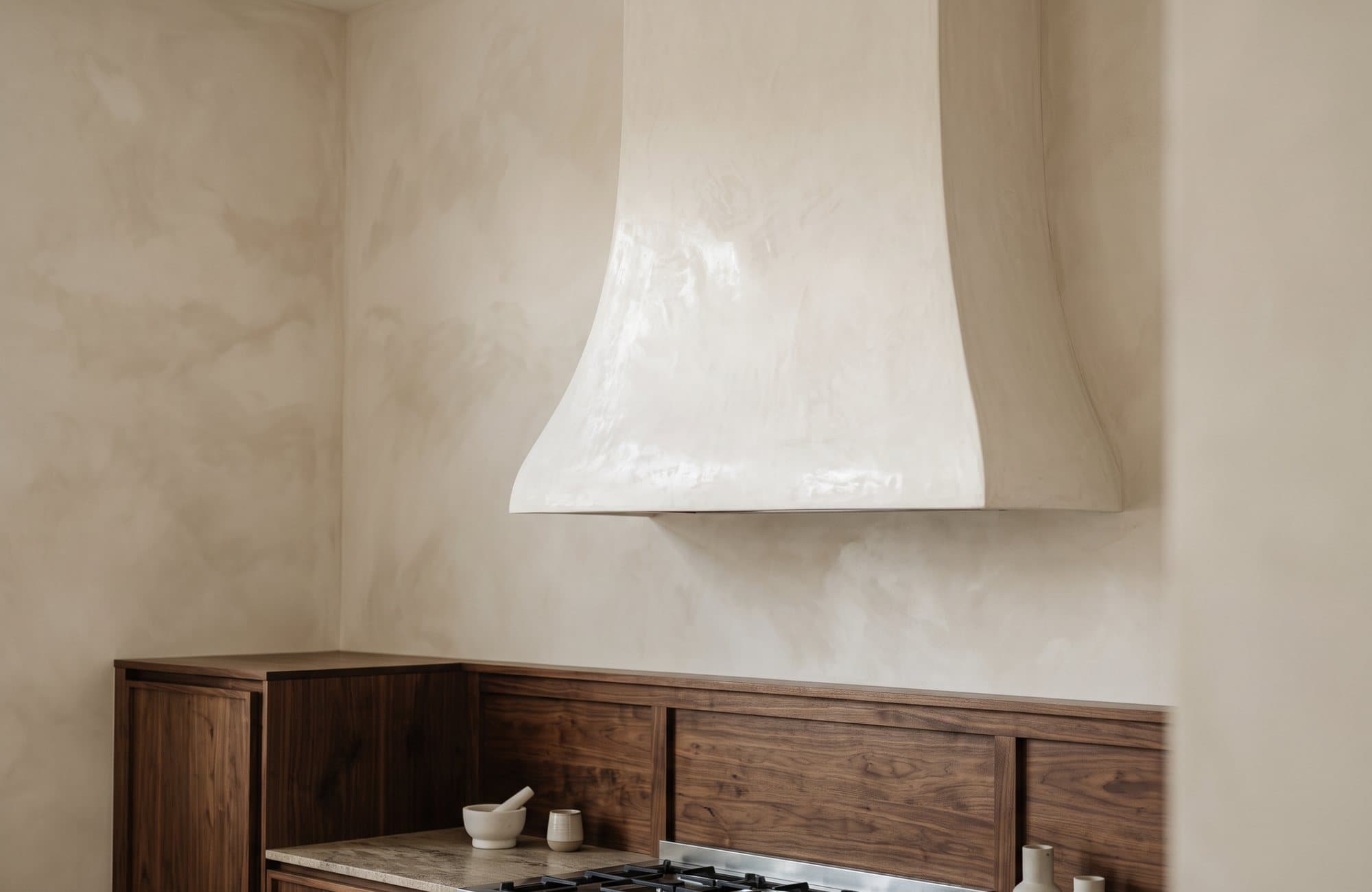 The curved plaster hood from an angle, against a cloudy limewash wall