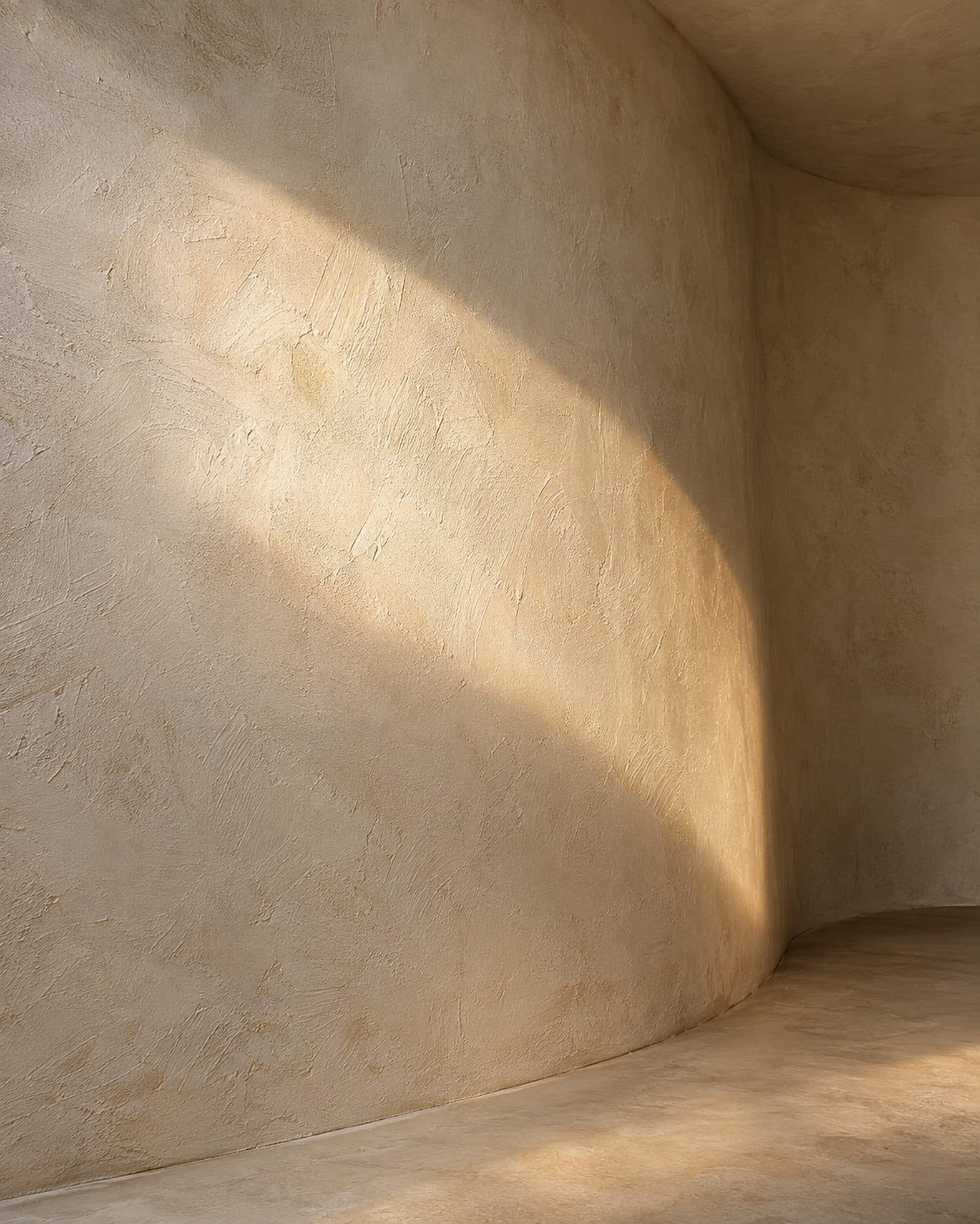 A curved plaster wall with a band of raking sunlight across it
