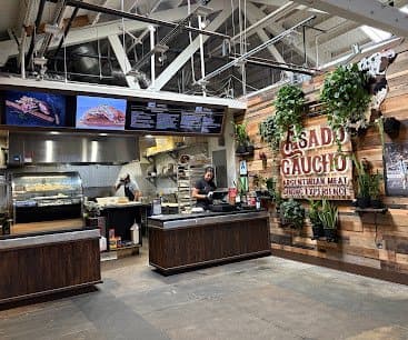 Asado Gaucho kitchen and counter with the restaurant sign on the wall